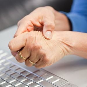 A person rubbing painful hands. Arthritis.